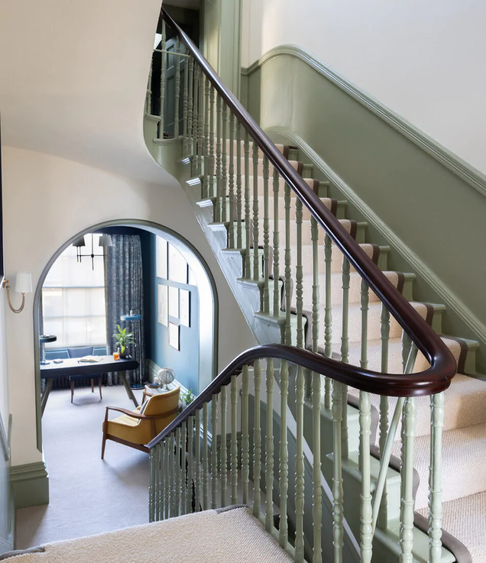 Firs floor hallway showing stairs and balustrade design, Spindles and half height panelling painted in green with dark oak hand rail