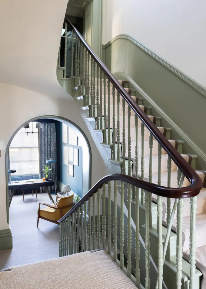 Firs floor hallway showing stairs and balustrade design, Spindles and half height panelling painted in green with dark oak hand rail